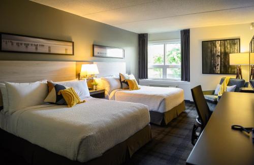una camera d'albergo con due letti e una finestra di Rodd Miramichi a Miramichi