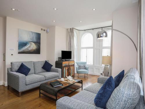 a living room with two couches and a table at Harlech Apartments - Branwen in Harlech