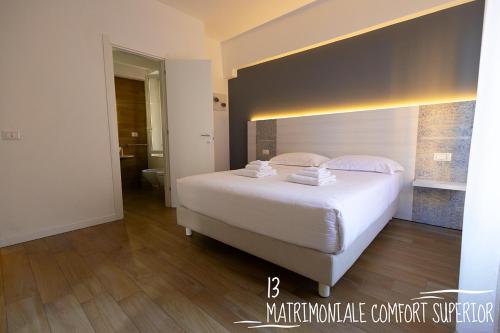a bedroom with a large white bed and a bathroom at Albergo Augusta B&B in Camogli