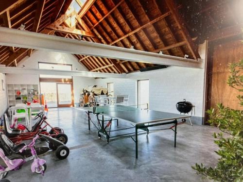 a ping pong table in the middle of a room at SCHRAVENHOEk met indoorzwembad en sauna in Veurne