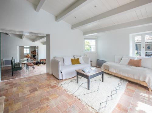 un salon avec un canapé et une table dans l'établissement Île de Ré - 9 personnes - Plage à pieds - Piscine, à Saint-Clément-des-Baleines