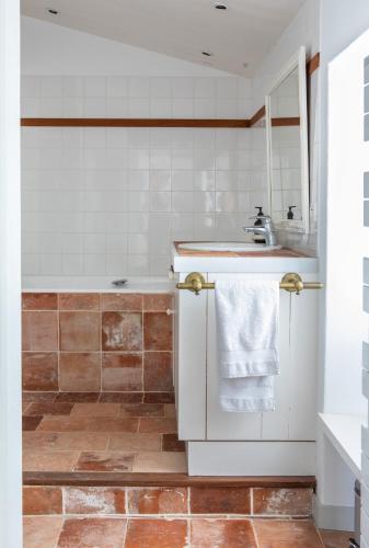 une salle de bain avec un lavabo et une baignoire dans l'établissement Île de Ré - 9 personnes - Plage à pieds - Piscine, à Saint-Clément-des-Baleines