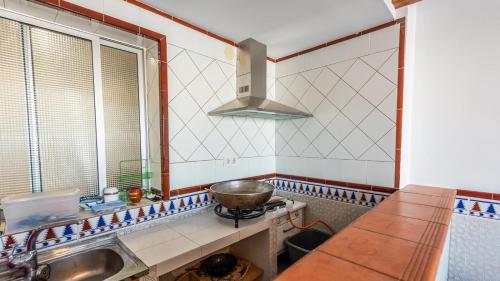 kuchnia ze zlewem i miską na kuchence w obiekcie Casa Medina de Güevéjar by Ruralidays w mieście Güevéjar