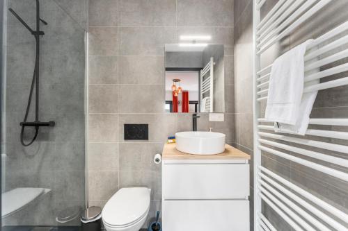 a bathroom with a sink and a toilet and a mirror at The Chocolate Suites in Bruges