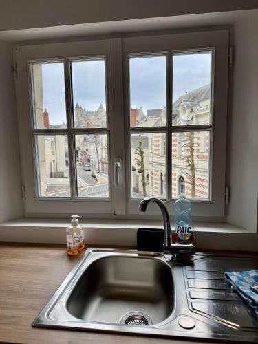 d'un évier de cuisine avec vue sur une fenêtre. dans l'établissement Appartement centre ville climatisé vue Château, à Saumur