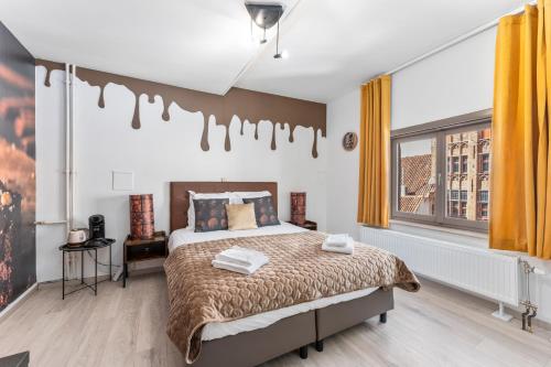 a bedroom with a bed and a large window at The Chocolate Suites in Bruges