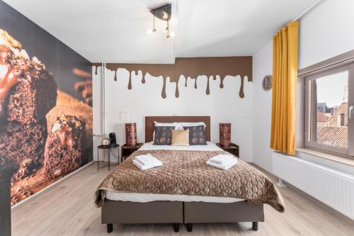 a bedroom with a bed and a large window at The Chocolate Suites in Bruges