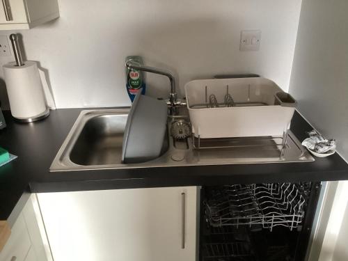 a kitchen sink with a dish drying rack next to it at Scalpay@Knock View Apartments, Sleat, Isle of Skye in Teangue