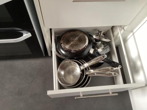 a bunch of pots and pans in a kitchen drawer at Scalpay@Knock View Apartments, Sleat, Isle of Skye in Teangue