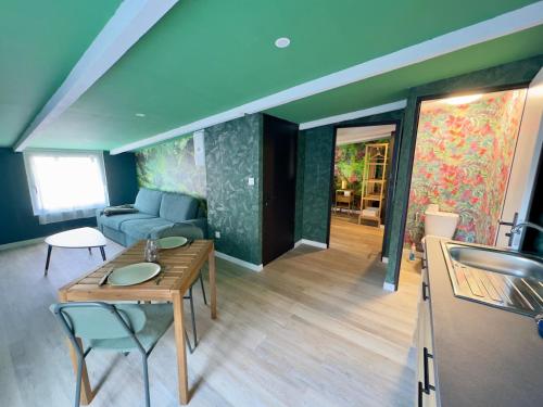 a living room with a table and a couch at Suite Tropical-Netflix-Parking in Douai