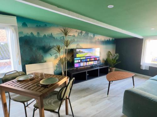 a living room with a table and a tv at Suite Tropical-Netflix-Parking in Douai