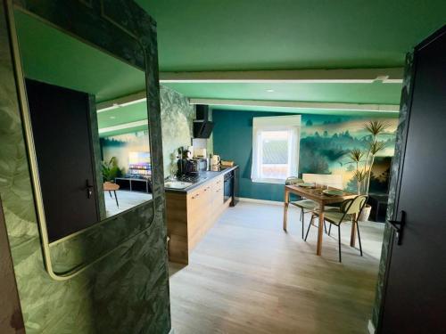 a kitchen with a table and a dining room at Suite Tropical-Netflix-Parking in Douai