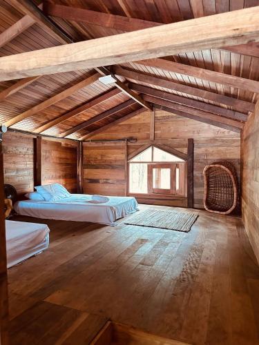 a large room with two beds and a wooden ceiling at CHALÉ SAMAÚMA | Banheira de Hidromassagem | Rede Suspensa | Decks de frente para praia in Belém
