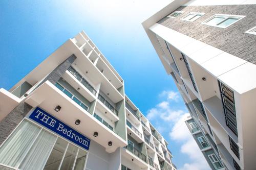 a tall white building with a blue sign on it at The Bedroom Ladprao 101 Bangkok - SHA in Bangkok