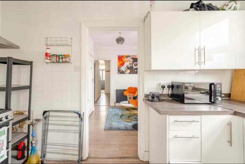 a kitchen with white cabinets and a counter top at Private Room in Uxbridge near Heathrow in Uxbridge