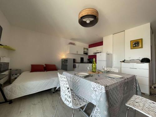 une chambre avec un lit, une table et des chaises dans l'établissement Studio LA ROCHELLE LR180-054, à La Rochelle