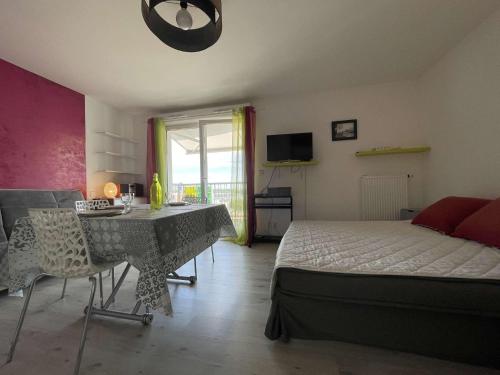 une chambre avec un lit, une table et des chaises dans l'établissement Studio LA ROCHELLE LR180-054, à La Rochelle