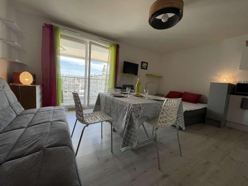 un salon avec une table, des chaises et un canapé dans l'établissement Studio LA ROCHELLE LR180-054, à La Rochelle
