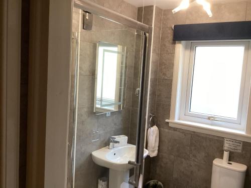 a bathroom with a sink and a shower at Scalpay@Knock View Apartments, Sleat, Isle of Skye in Teangue