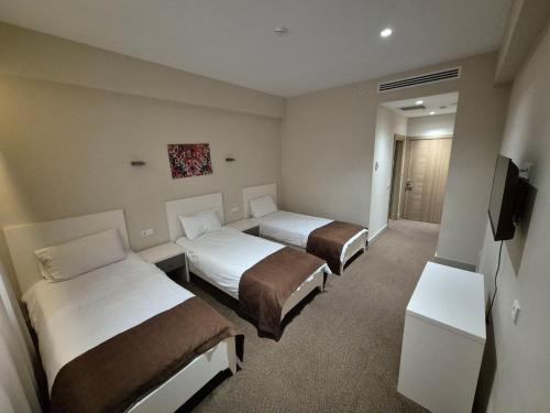 a hotel room with two beds and a flat screen tv at Arena Hotel Goranboy in Goranboy