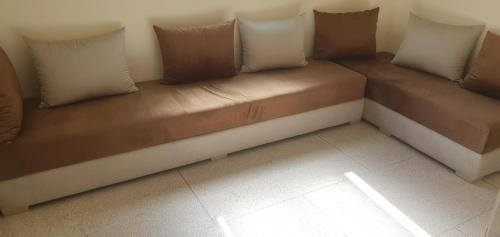 a couch with pillows sitting in a room at hôtel mamounia el hajeb in El Hajeb