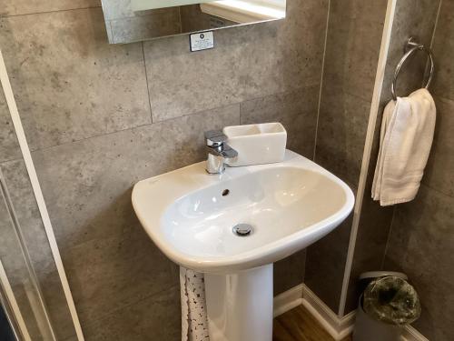 a bathroom with a white sink and a mirror at Scalpay@Knock View Apartments, Sleat, Isle of Skye in Teangue