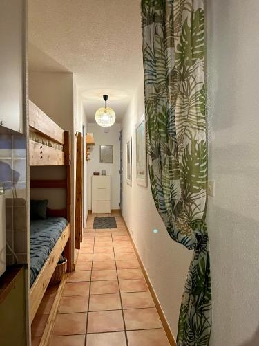- un couloir avec une chambre dotée d'un lit et d'un rideau dans l'établissement T2 cabine relooké avec piscine idéalement situé, à Gruissan