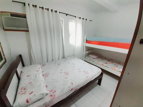 Postel nebo postele na pokoji v ubytování Casa em condomínio, com piscina, parquinho infantil, internet 500mb, ideal para família, garagem para 2 carros, com 2 quartos sendo 1 suíte, com Smart TV, 400m da PRAIA