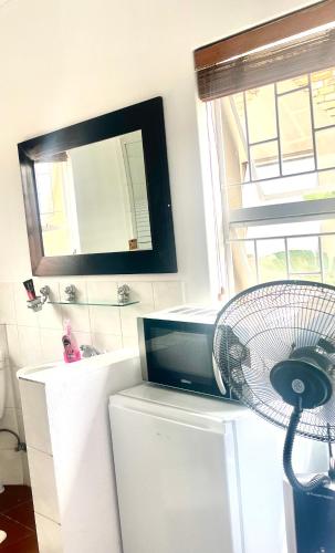 a bathroom with a fan on top of a refrigerator at Plaisir de recevoir in Roodepoort