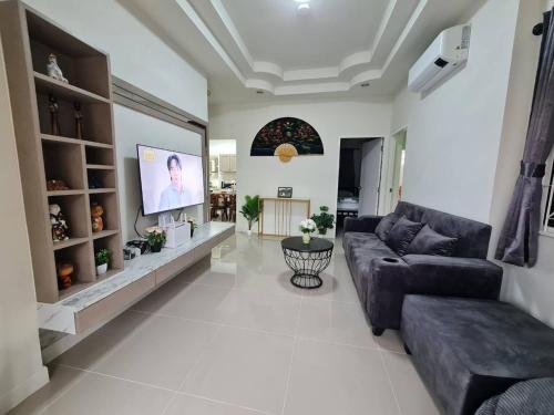 a living room with a couch and a tv at Perfect Home 15 mins from airport in Chiang Mai