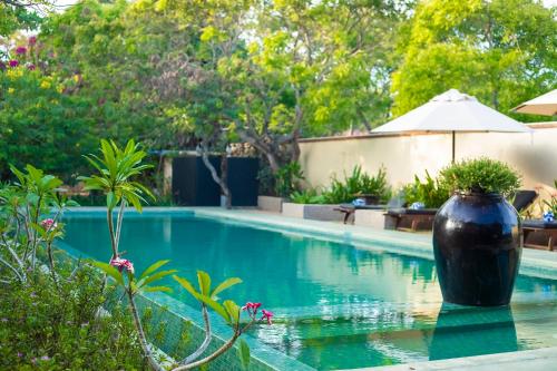 a large black vase sitting in the middle of a swimming pool at NIKARA Luxury Beach House in Tissamaharama