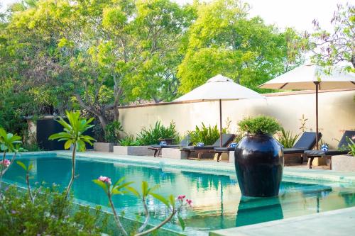 a large black vase sitting next to a swimming pool at NIKARA Luxury Beach House in Tissamaharama