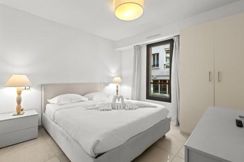 une chambre blanche avec un grand lit et une fenêtre dans l'établissement VIP 2 chambres, 2 salles de bain et 2 WCs Palais des Festivals Croisette, à Cannes