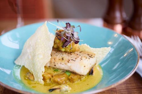 a blue plate with a piece of fish and nachos at Hotel Victoria in Whitby