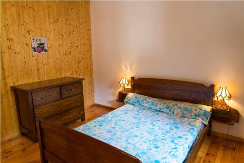 - une chambre avec un lit, une commode et deux lampes dans l'établissement Location a chanteperdrix 2 personnes, à Sainte-Énimie