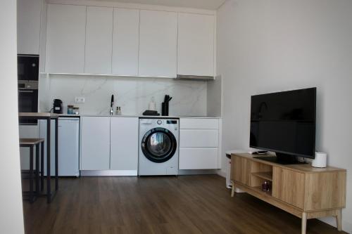 a kitchen with a washing machine and a tv at Like Home I - vista mar e ambiente relaxante in Funchal