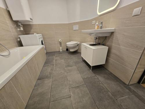 a bathroom with a sink and a toilet and a bath tub at Aldrans Apartment with 3 bedrooms in Innsbruck