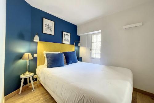 une chambre avec un grand lit aux murs bleus dans l'établissement 1 Bedroom Ideal Location Cannes, à Cannes