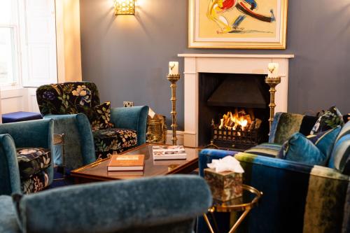 a living room with chairs and a fireplace at Aynsome Manor in Cartmel
