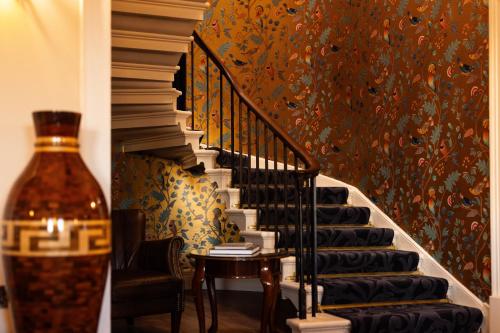 a staircase with a table and a vase next to it at Aynsome Manor in Cartmel