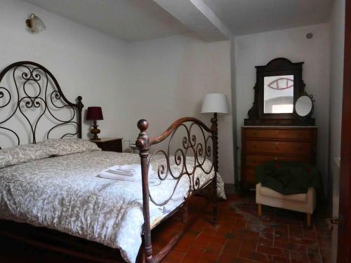 a bedroom with a bed and a dresser and a mirror at La Meridiana in Montefioralle in Greve in Chianti