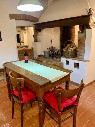 a kitchen with a wooden table with two chairs and a fireplace at La Meridiana in Montefioralle in Greve in Chianti