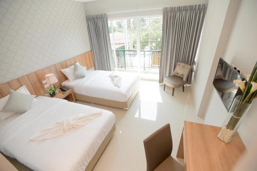 a hotel room with two beds and a balcony at The Bedroom Ladprao 101 Bangkok - SHA in Bangkok