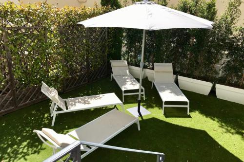 un groupe de chaises et un parasol sur l'herbe dans l'établissement Marvellous 5 bed Cannes Centre, à Cannes