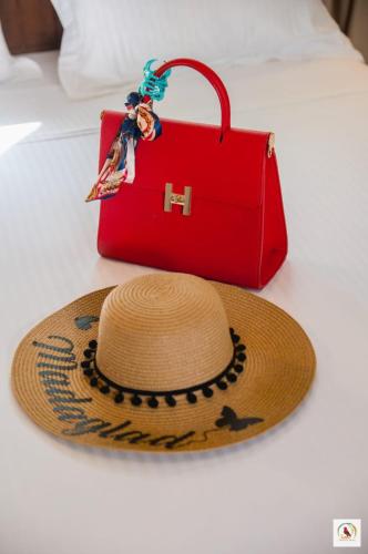 a straw hat and a red purse on a table at Palmares Beach Hotel in Andjamen