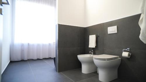 a bathroom with a white toilet and a window at Harbour Front - Luxury Rooms in Palermo