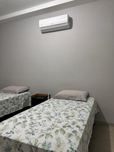 a bedroom with two beds and a light on the wall at The Wall in Araçatuba