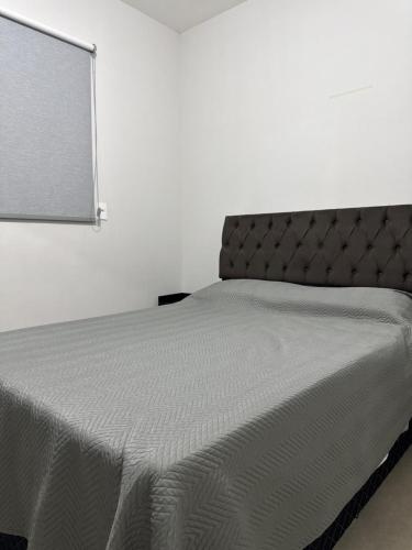 a bed in a white room with a white wall at The Wall in Araçatuba