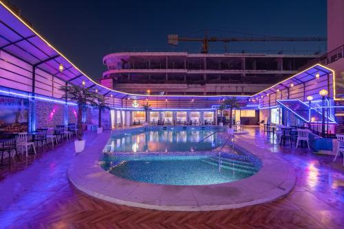 a pool in the middle of a building at night at Grand Ambassador Hotel in Dubai