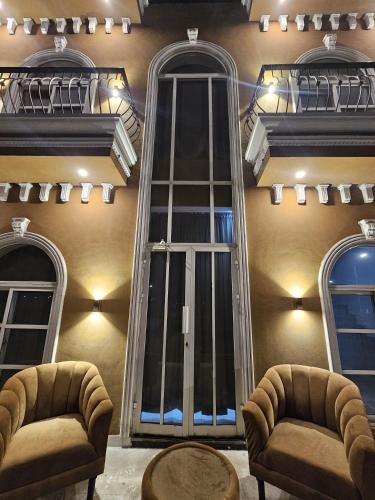 a building with a large window and two chairs at S H Residence & APARTMENTS in Mūsapur
